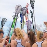 Girls Lacrosse team holding up lacrosse sticks